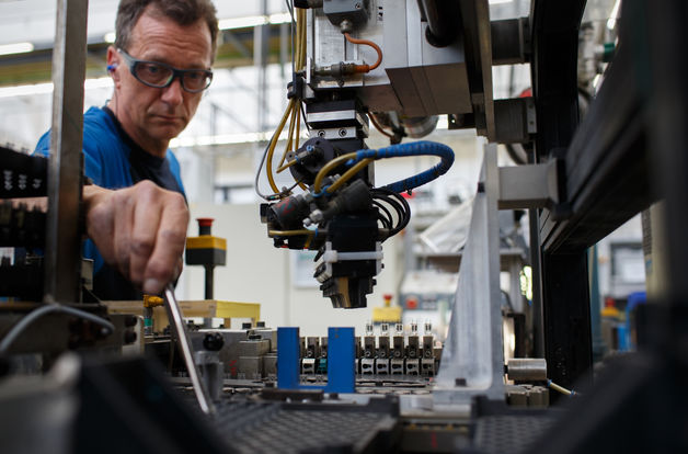 An employee works on the halogen light production line at the Royal Philips NV automotive lighting factory in Aachen, Germany